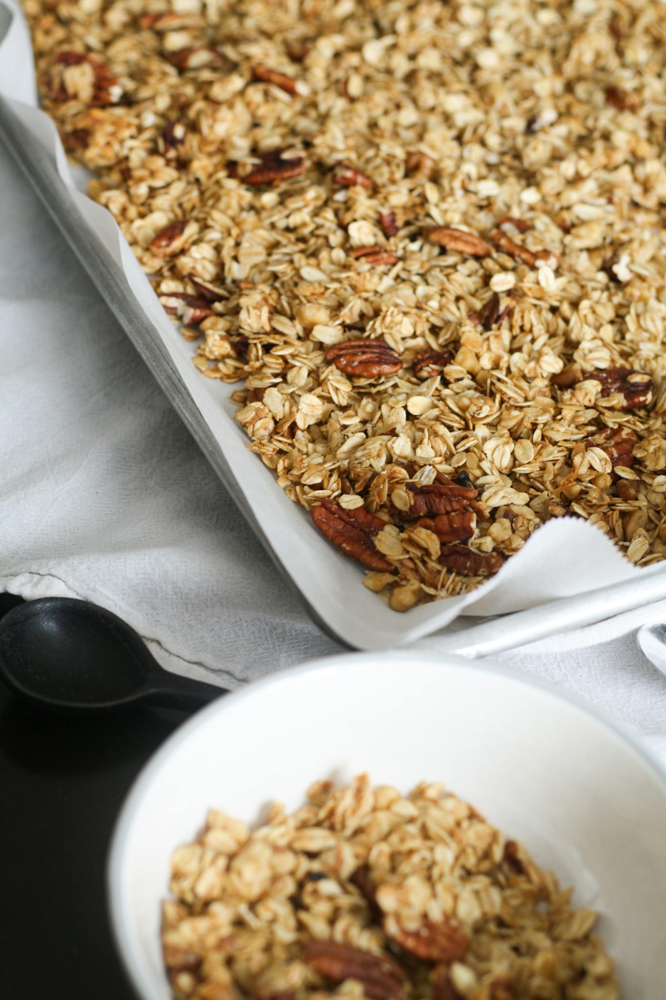 Freshly baked homemade granola with pecans in a kitchen setting, perfect for a healthy breakfast.