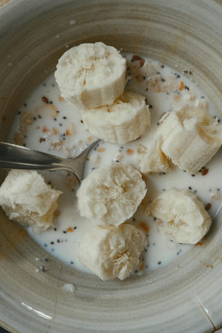 Healthy breakfast bowl with sliced bananas, oats, and milk.