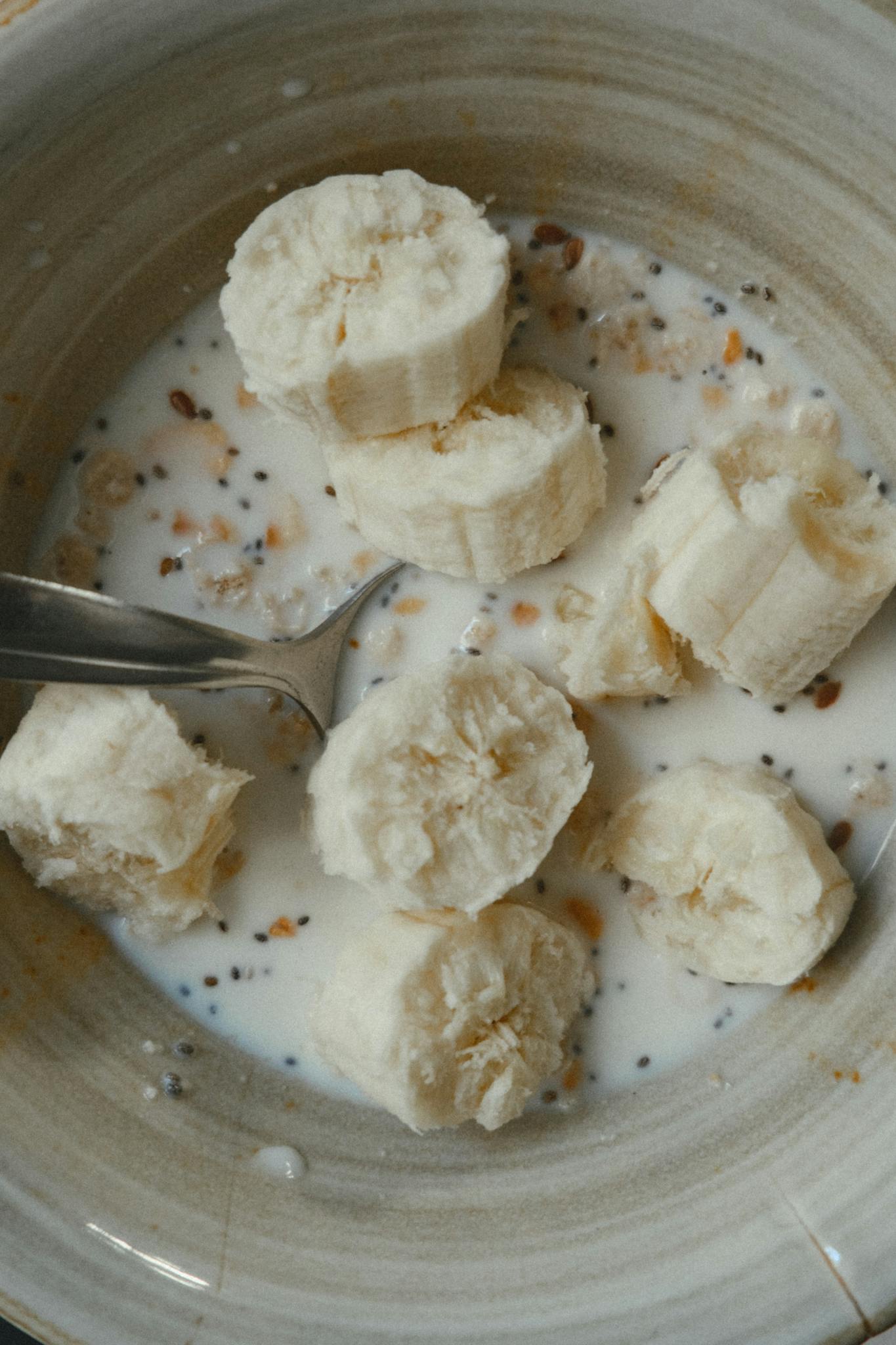 Healthy breakfast bowl with sliced bananas, oats, and milk.